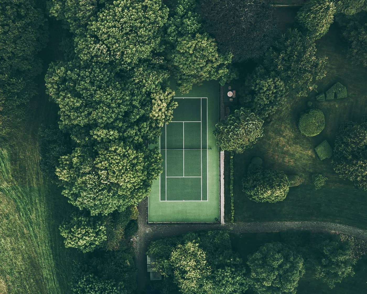 Aerial view of a tennis court surrounded by trees